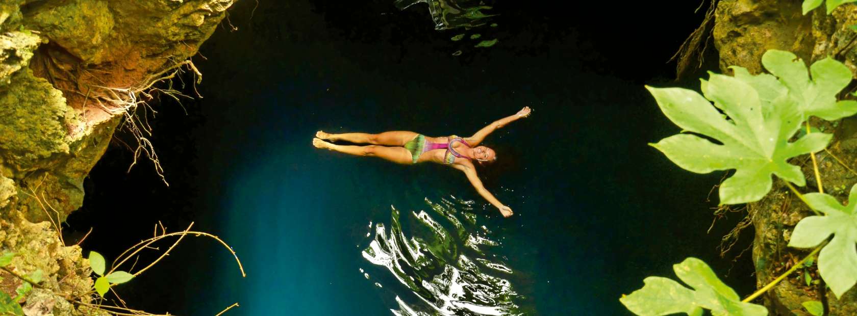 Woman Floating in Cenote Pool