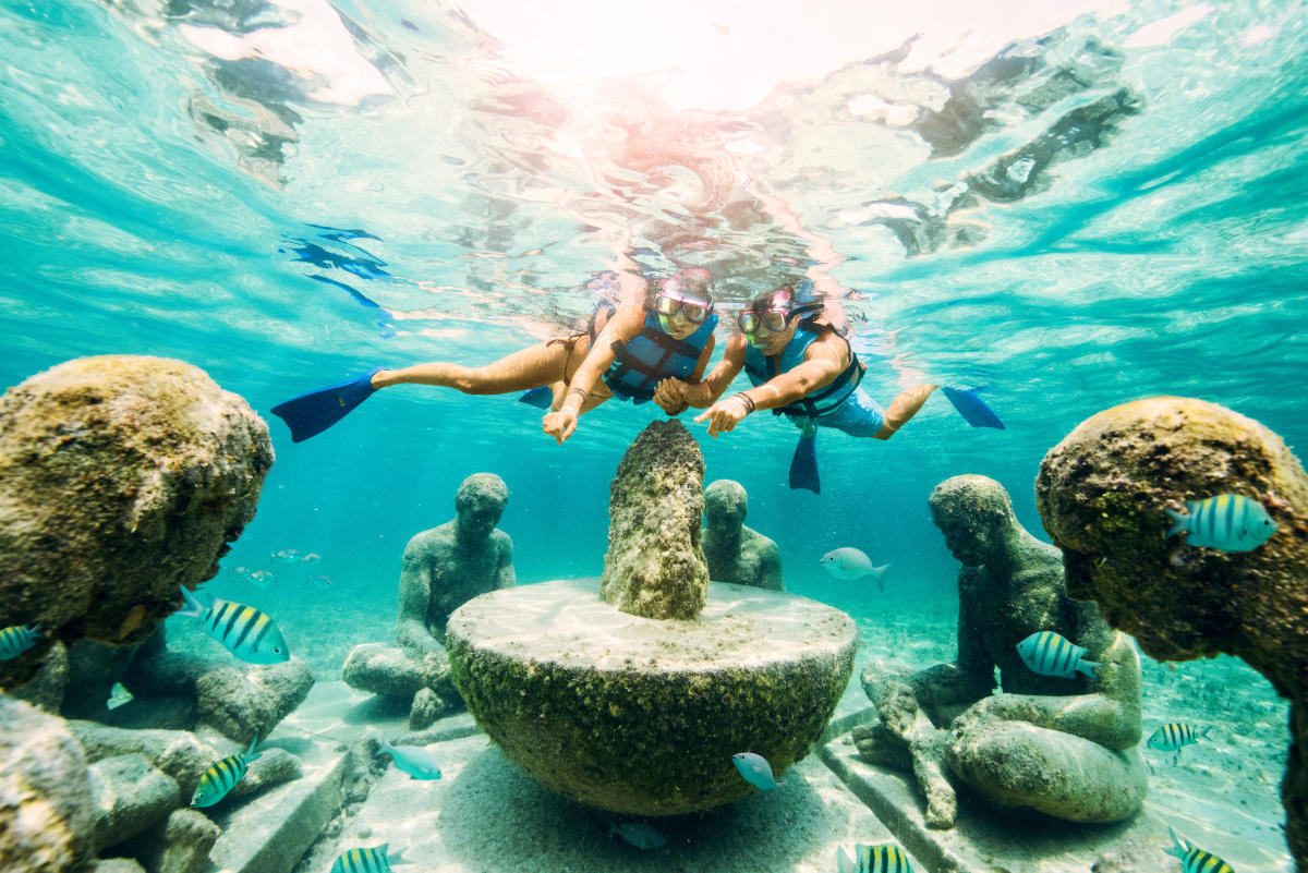 Snorkelers looking at underwater sculptures