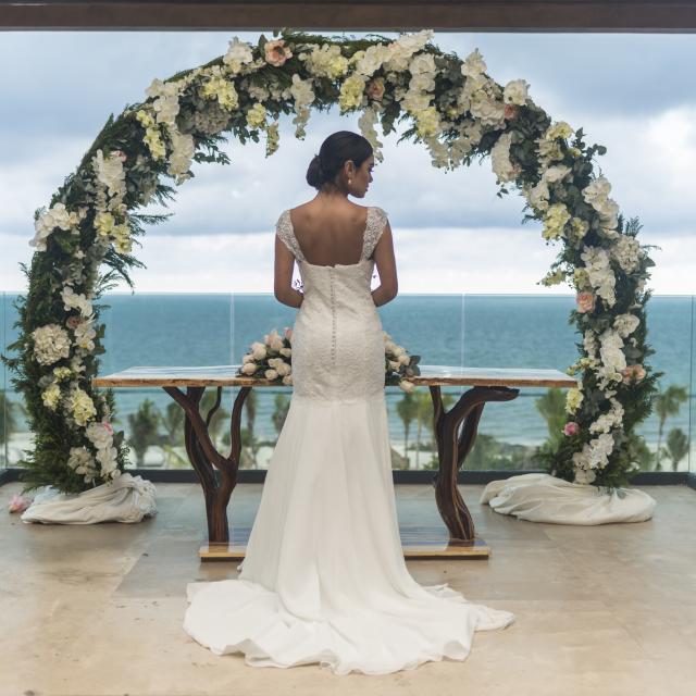 Bride in front of elaborate floral arrangement
