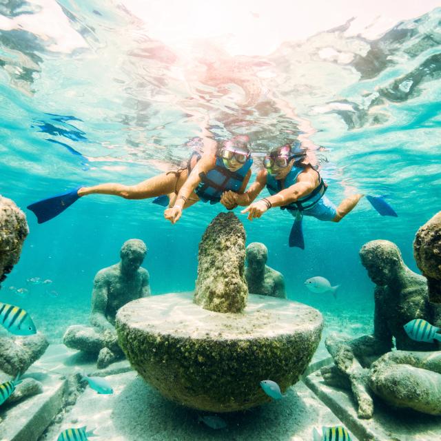 Snorkelers looking at underwater sculptures